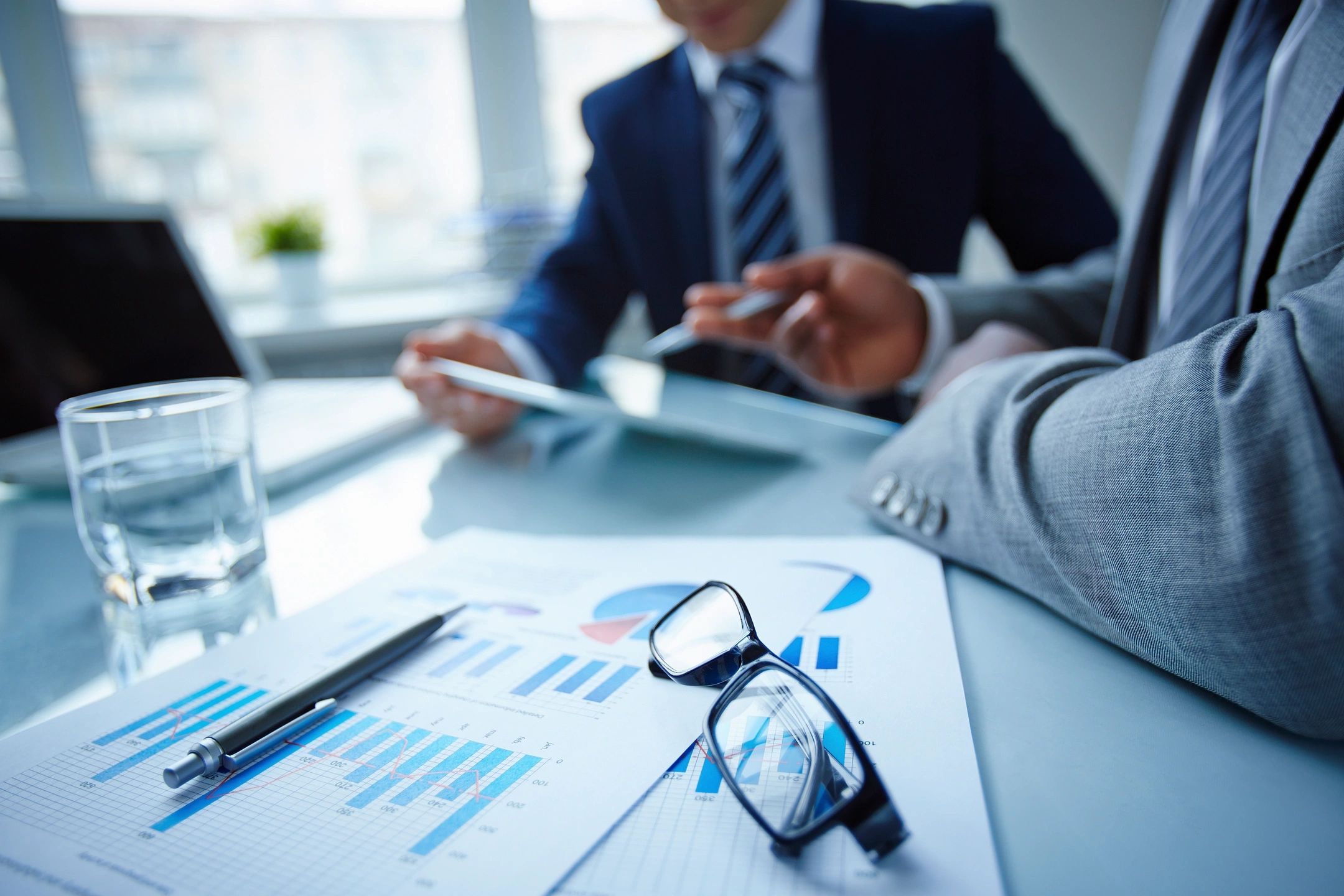 Business meeting with graphs and glasses